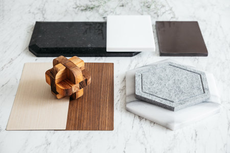 Material Selections including Granite tile, Marble tile, Acoustic tile, Walnut and Ash Wood Laminate with plant and flowers on marble top table.の写真素材