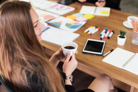 Close-up Caucasian businesswoman sitting and holding a cup of coffee while listening to a partnership consulting meeting. Brainstorming new business project finance investment concept. Selective focusの写真素材