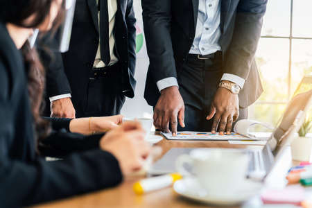 Close-up hands of African businessman planning and discuss with Caucasian colleagues that looking on...