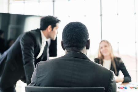 Back of the African businessman shares his opinion at a business group meeting, Discussion about new business plan in the office. Business People of various nationalities.の写真素材