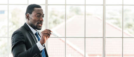 Close-up African businessman leads the meeting, briefing and pointing a marker pen. the discussion of a new business plan in the office. Businesspeople of various nationalities. Image with copy space.の写真素材