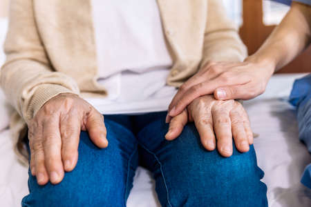 Close-up senior Asian woman hand with her caregiver helping hands, Caregiver visit at home. Home...
