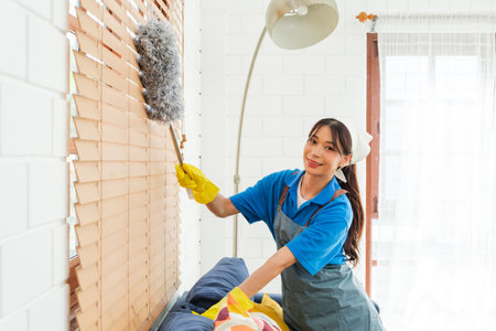 Asian young professional cleaning service woman worker working in the house. The girl cleans the...