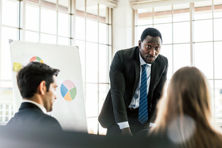 African businessman presents and listens to opinions at a business group meeting, Discussion about...