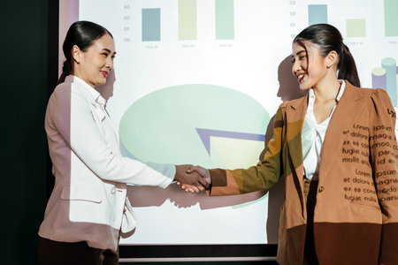 Asian businesswoman handshake with businessman, the teamwork of business mergers and acquisitions for successful negotiation. Two businessmen shake hands with partners to celebrate business deals.の写真素材