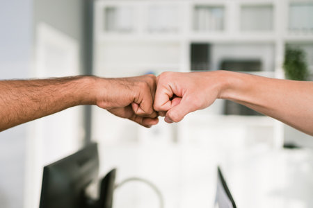 Cheerful Asian businessman partners making fist bump with a smile as a symbol of teamwork. Positive multi-ethnic business colleagues on diversity in the office. Collaboration conceptの写真素材
