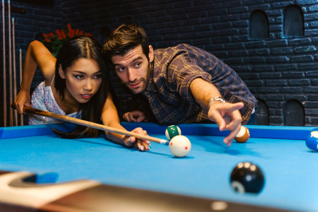 Young diversity group of people playing pool together with smile, enjoyment and fun. Young people...