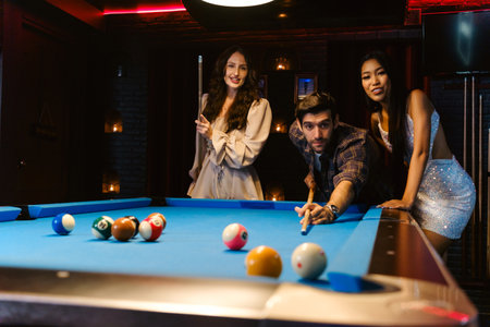Young diversity group of people playing pool together with smile, enjoyment and fun. Young people...