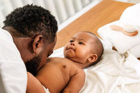 A tender moment between an African father and his baby, showcasing love and bonding during a care...