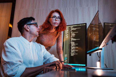Developers learning to code together on multiple screens. Modern teamwork, coding skills, and technology in business concepts highlighting software development, innovation, and digital growth.の写真素材
