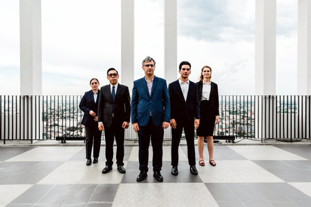 Diverse business team in formal attire standing on a modern rooftop terrace with city skyline views,...