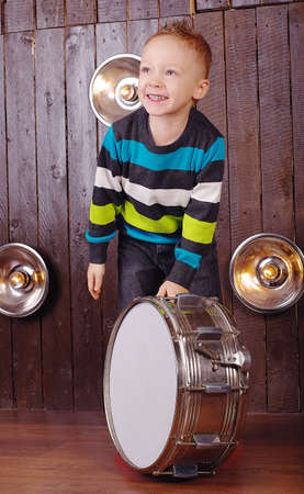 laughing boy playing fun on the drumの写真素材