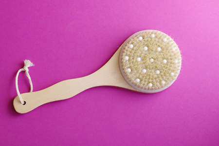 Spa massage wooden brush on purple background