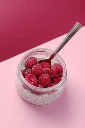 Pudding chia with coconut milk and raspberries on the pink background. Sugarless. Healthy and diet...