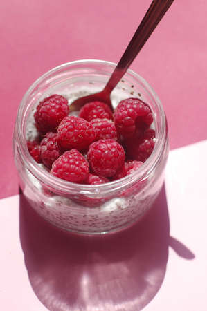 Pudding chia with coconut milk and raspberries on the pink background. Sugarless. Healthy and diet...