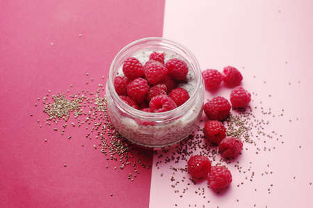 Pudding chia with coconut milk and raspberries on the pink background. Sugarless. Healthy and diet...