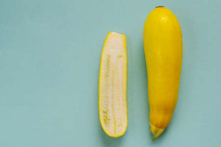 yellow courgette whole and half. Fresh multicolored zucchini on a blue backgroundの写真素材
