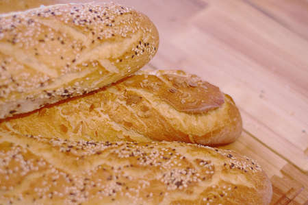 French baguette on the wooden cutting board. Green grass on the background  Close-up. Selective...