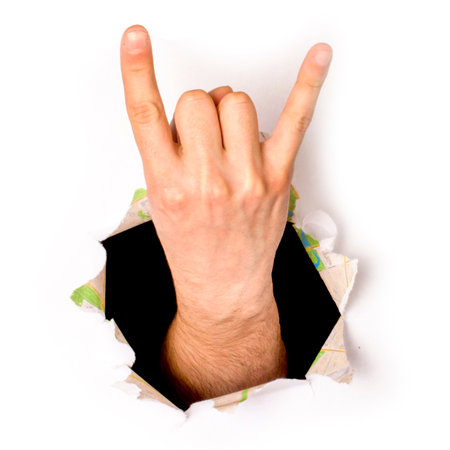close-up of a hand coming out of a hole in white paper, a rock and roll sign, isolatedの写真素材