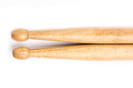 Two wooden drum sticks lying on each other isolated on white backgroundの写真素材