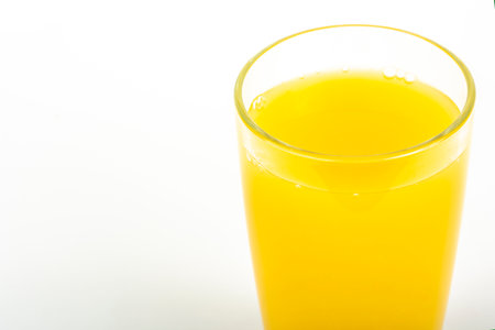 Orange juice yellow-orange in glass isolated on whiteの写真素材