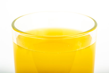 Orange juice yellow-orange in glass isolated on whiteの写真素材