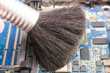Cleaning the motherboard from dust and debris with a brushの写真素材