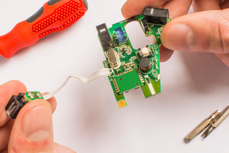 board in hands on a white background with a red screwdriver and interchangeable tips with a...