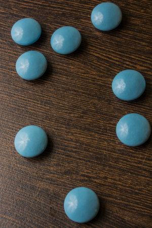 A pile of blue capsules pills on a wooden table backgroundの写真素材