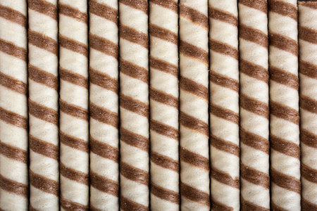 Striped waffle rolls filled with chocolate closeup backgroundの写真素材