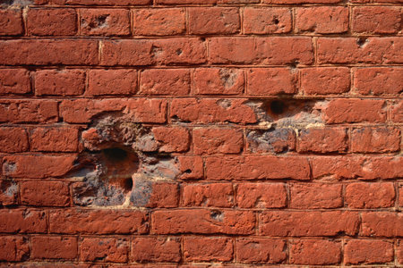 Old red brick wall with holes in the middle. abstract background.の写真素材