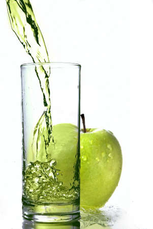 fresh apple juice in glass with green apple isolated on whiteの写真素材