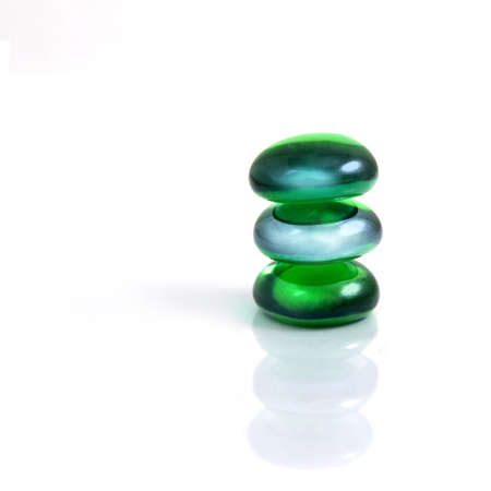 zen-like balancing spa green shiny stones isolated on whiteの写真素材