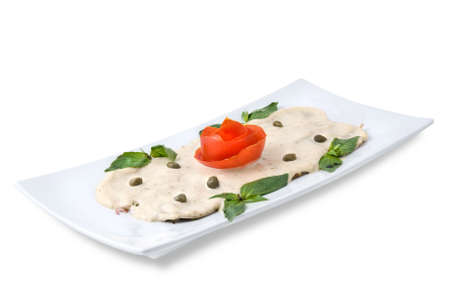 slices of ham with sauce on the plate isolated on whiteの写真素材
