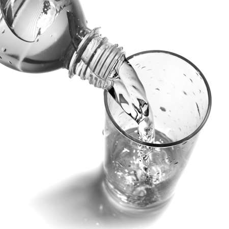 water pouring into glass from bottle isolated on whiteの写真素材