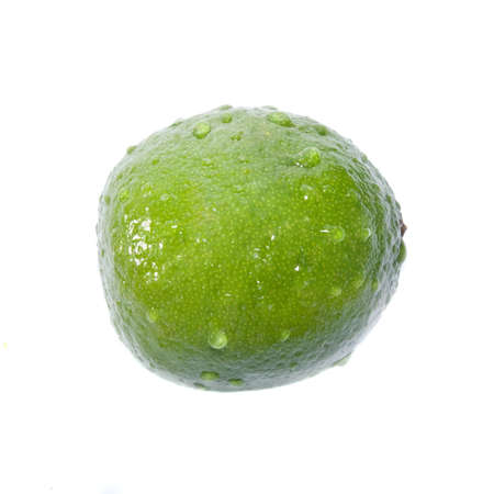 green lime with water drops isolated on whiteの写真素材