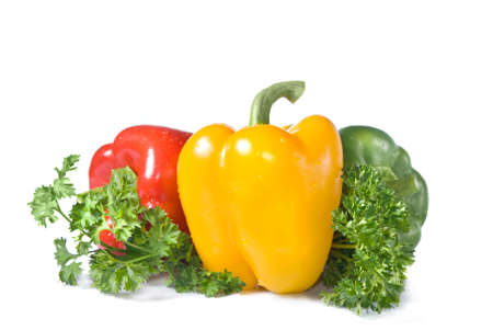 red, yellow and green pepper with parsley isolated on whiteの写真素材