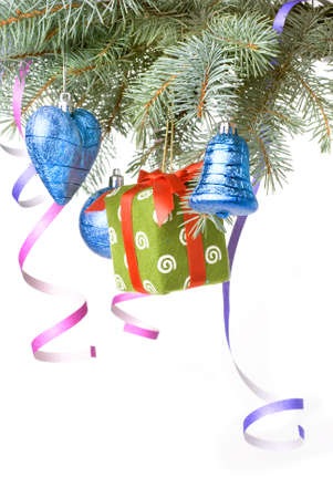 Christmas balls, gift and decoration on fir tree branch isolated on whiteの写真素材