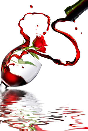 Heart from pouring red wine in goblet isolated on whiteの写真素材