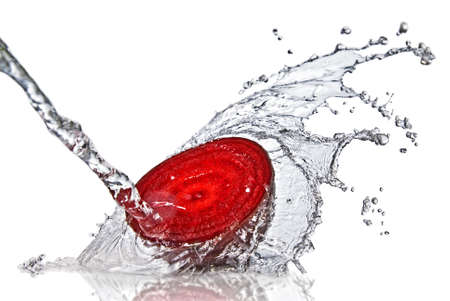 red beet with water splash isolated on white の写真素材