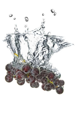blue grape dropped into water with splash isolated on whiteの写真素材