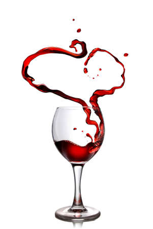 Heart from pouring red wine in goblet isolated on whiteの写真素材
