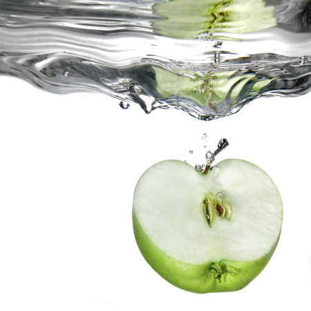 green apple dropped into water with splash isolated on whiteの写真素材
