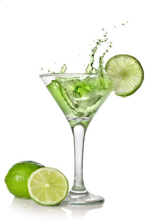 Green alchohol cocktail with splash and green lime isolated on whiteの写真素材