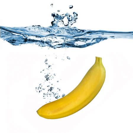 banana dropped into water isolated on whiteの写真素材