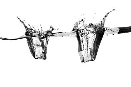 ice cubes dropped into water with splash isolated on whiteの写真素材