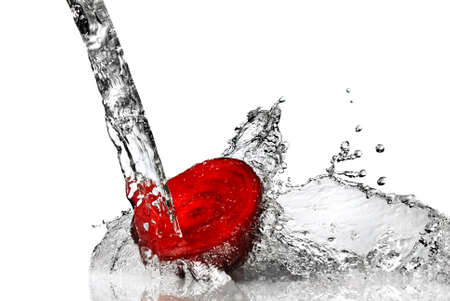 red beet with water splash isolated on whiteの写真素材