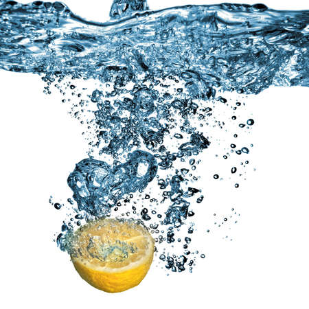 Fresh lemon dropped into water with bubbles isolated on whiteの写真素材