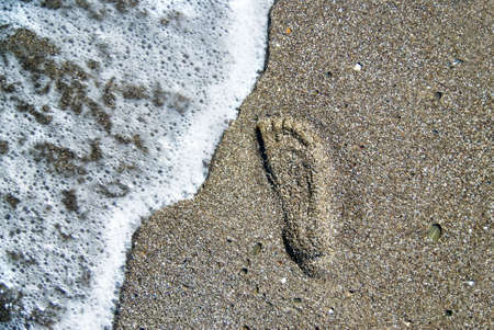 sand stones with footprint and water waveの写真素材