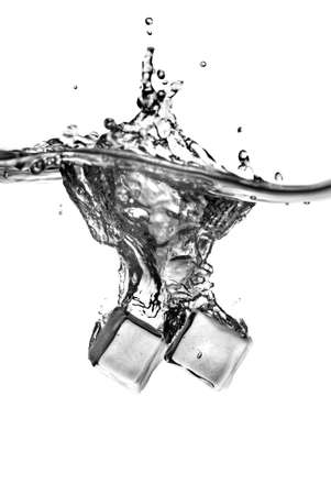 ice cubes dropped into water with splash isolated on whiteの写真素材
